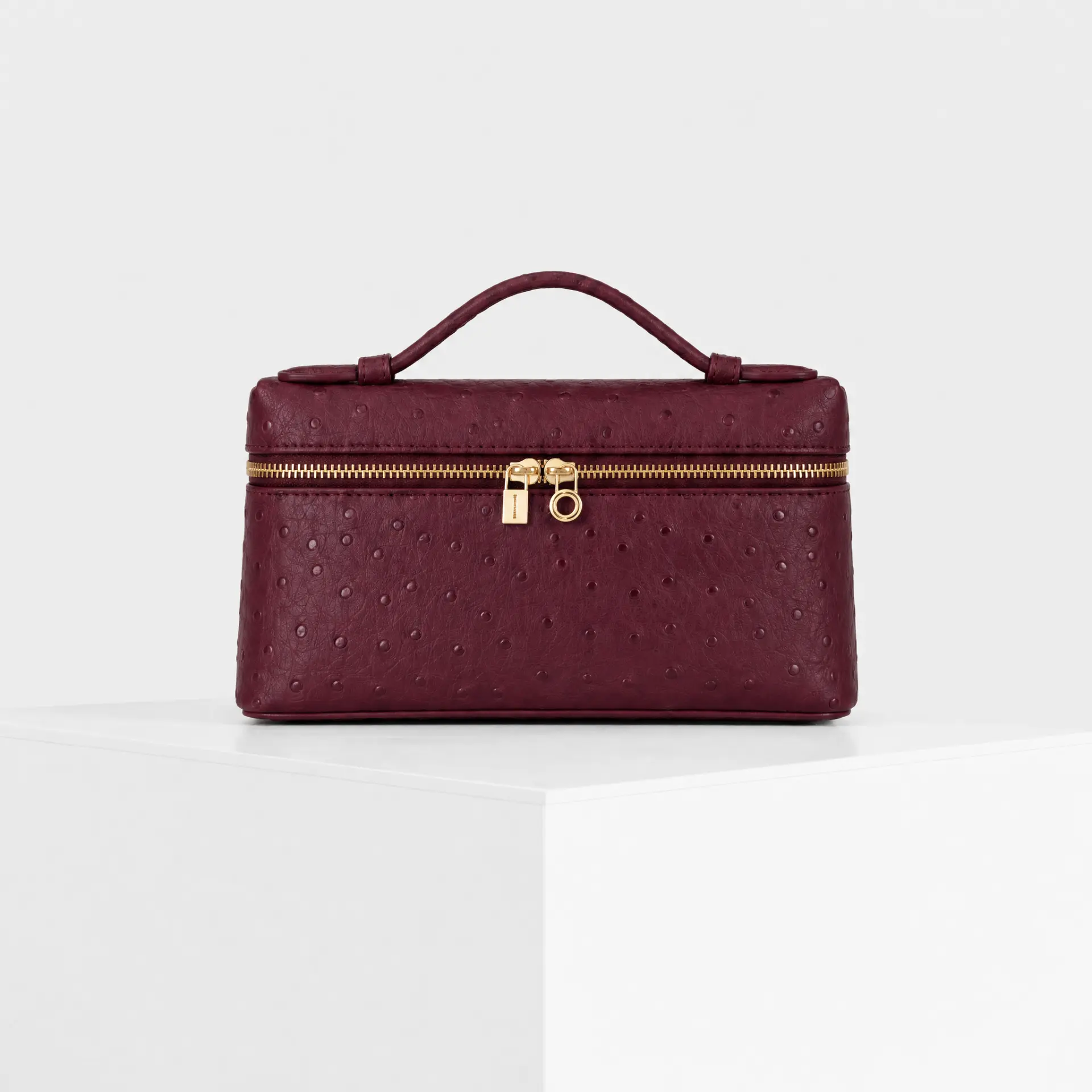 Deep burgundy wine ostrich-embossed top-handle mini case bag with gold hardware