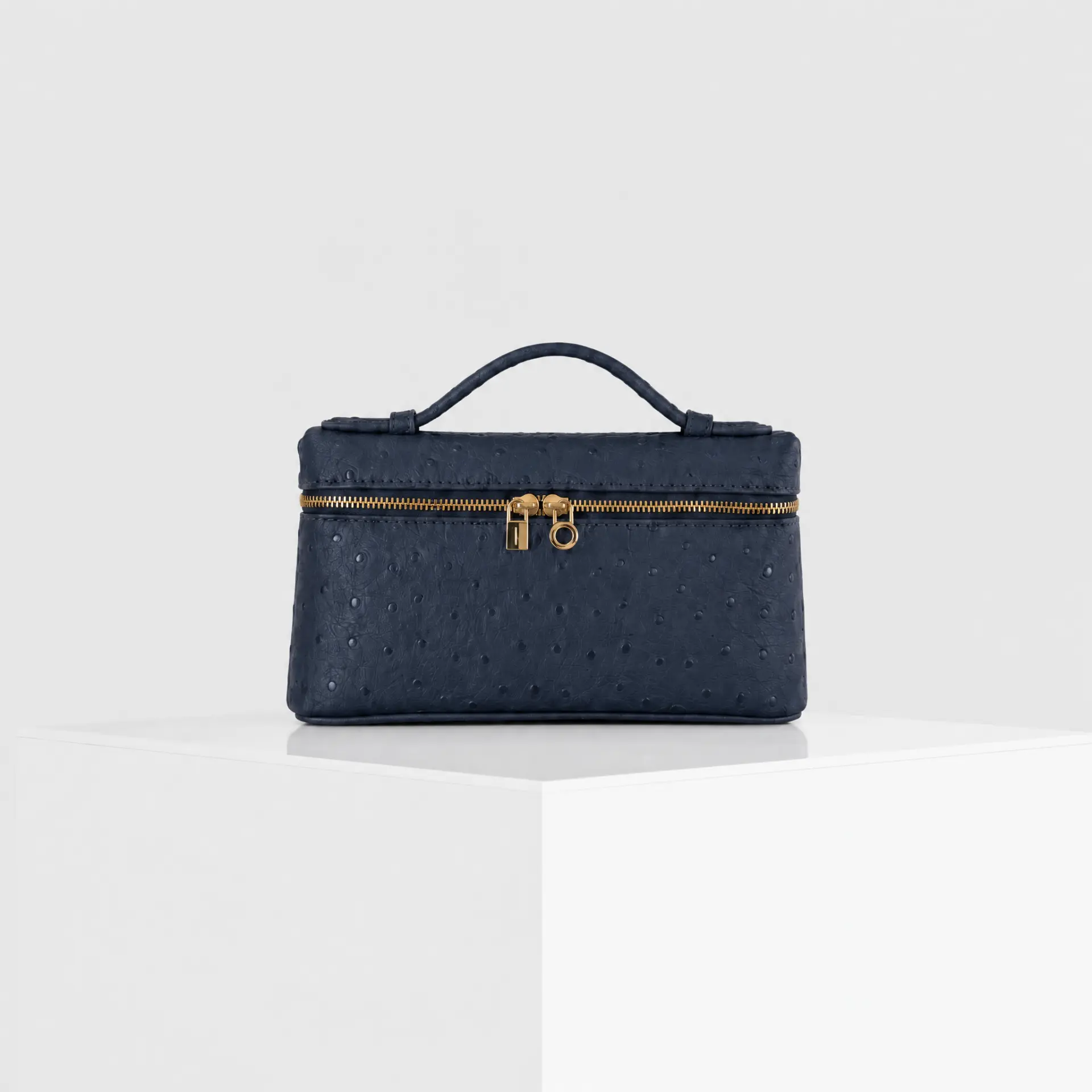 Navy blue ostrich-embossed top-handle mini case bag with gold hardware