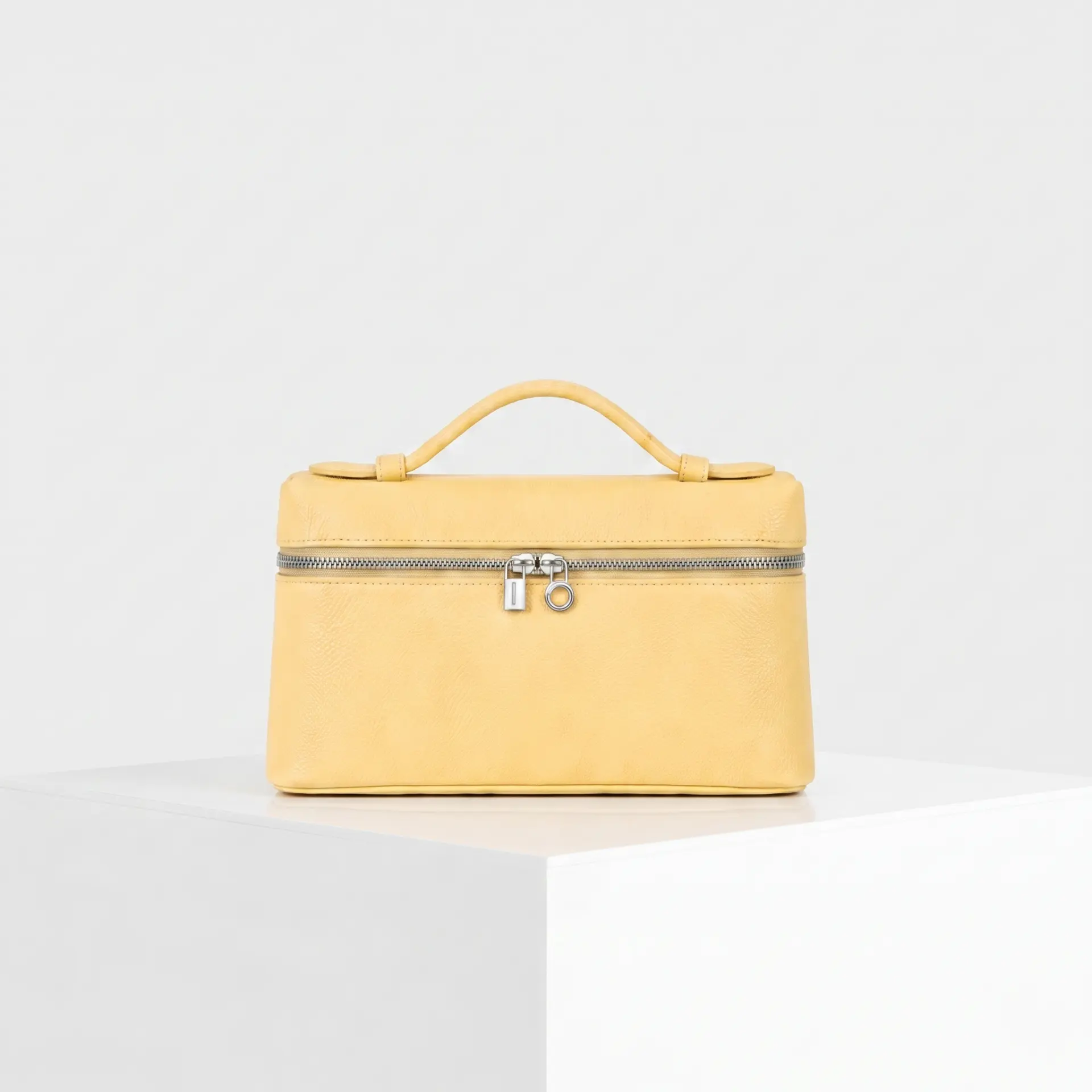 Pale butter yellow pebbled leather top-handle mini case bag with silver hardware